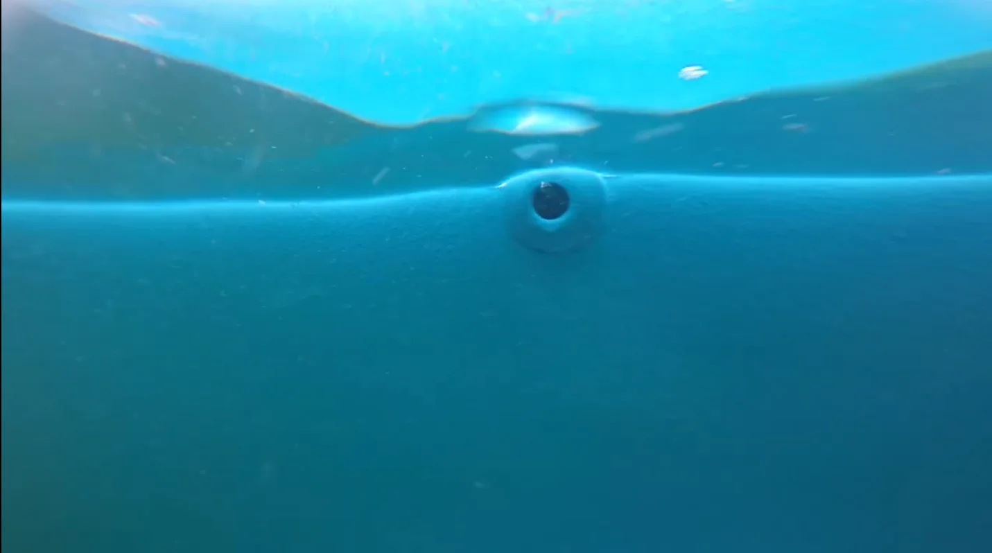 Commercial diver cleaning a barnacle-covered boat hull underwater in Victoria BC